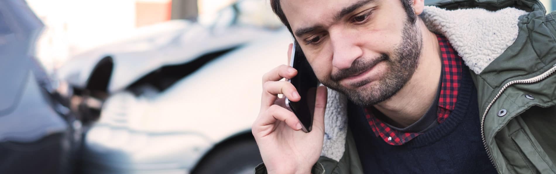 Man on cellphone after a car crash