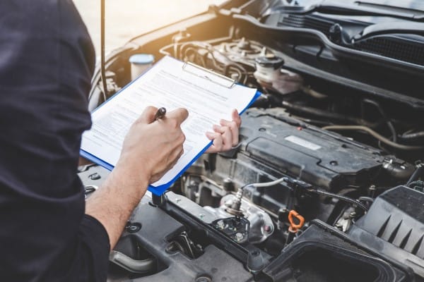 person inspecting car engine